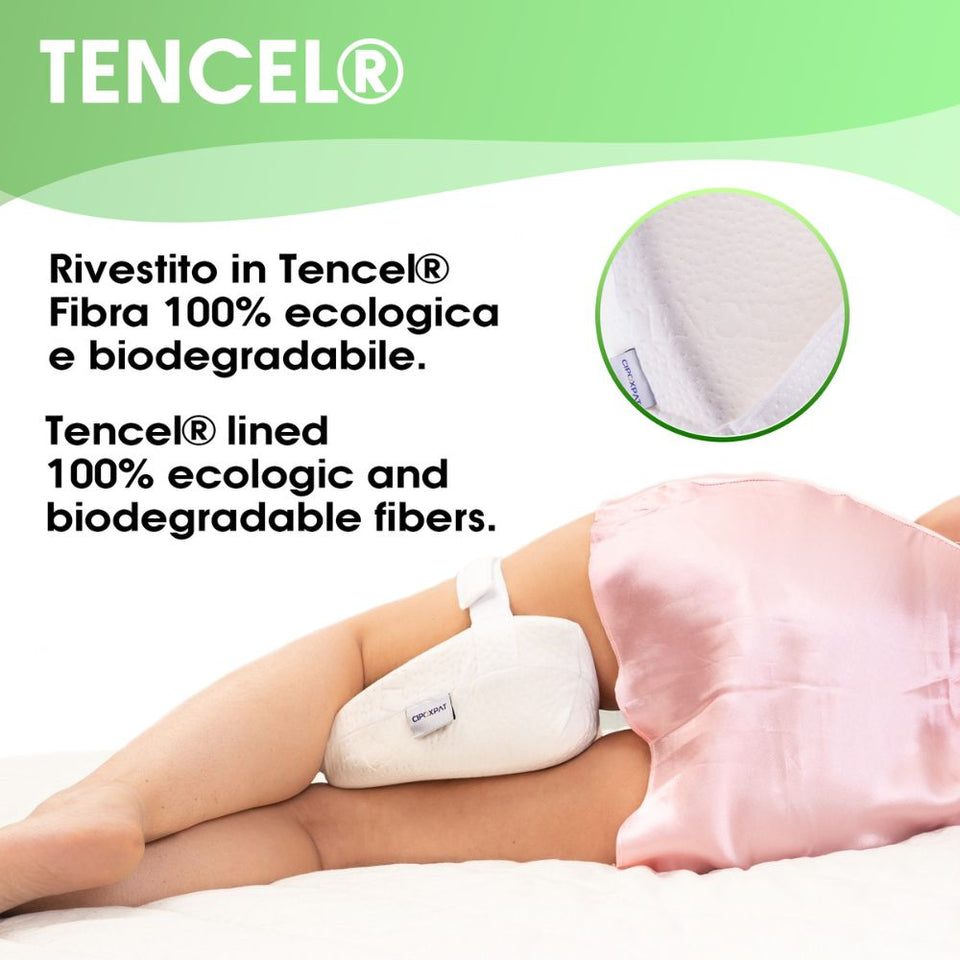 Immagine di donna distesa sul fianco con il cuscino in mezzo alle gambe con call out che mostra il rivestimento in Tencel, fibra ecologica e biodegradabile.